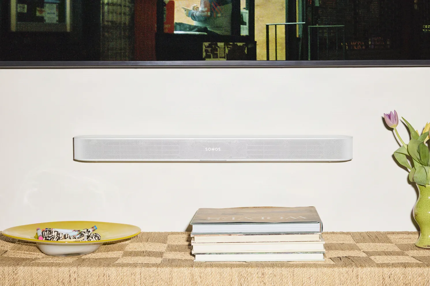 Witte Sonos Beam Ultra vlak aan de muur gemonteerd boven een dressoir